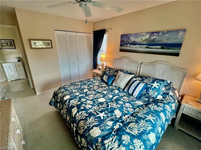 Carpeted bedroom featuring a closet, baseboards, and ceiling fan