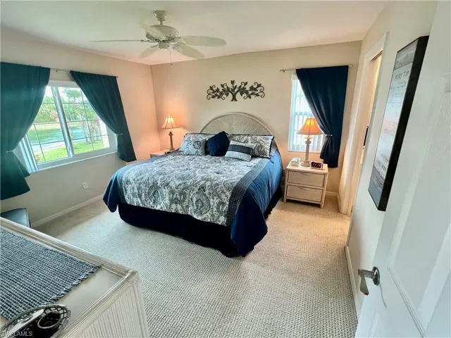 Bedroom featuring baseboards, light colored carpet, and ceiling fan