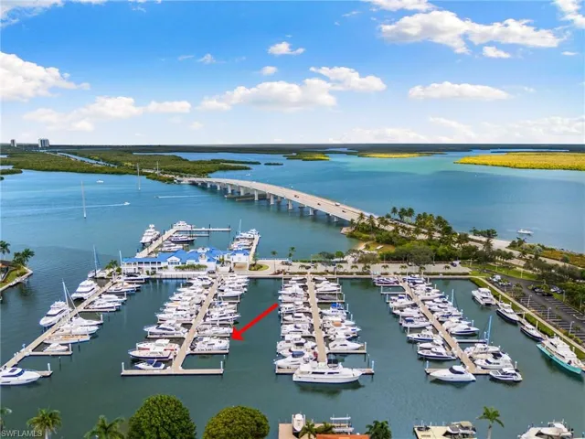 Bird's eye view of numerous boat docks, a large body of water, and a notable bridge