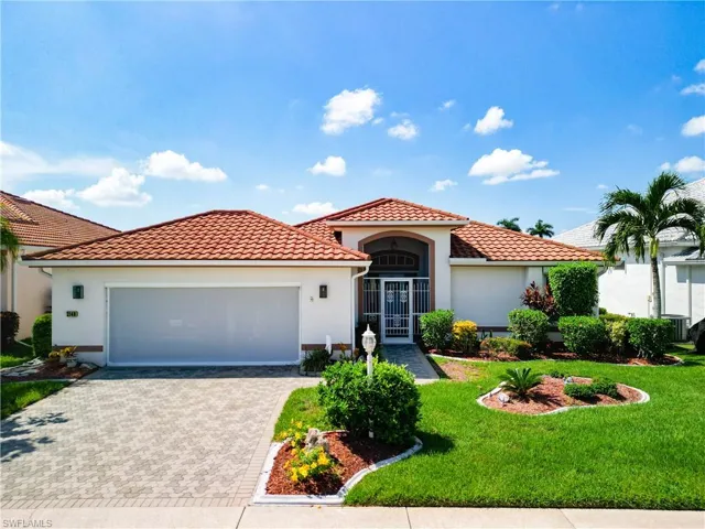 Mediterranean house featuring an expanded garage and a front yard