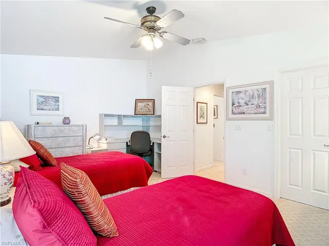 Guest Bedroom with ceiling fan, light carpet, and lofted ceiling