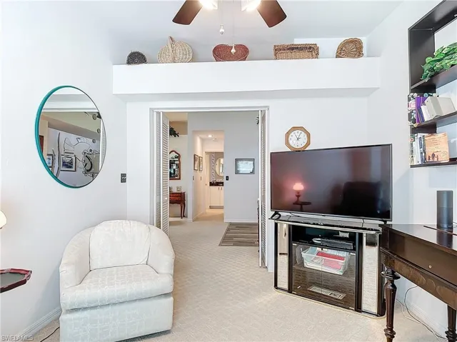 Carpeted den/3rd bedroom featuring ceiling fan and closing doorway