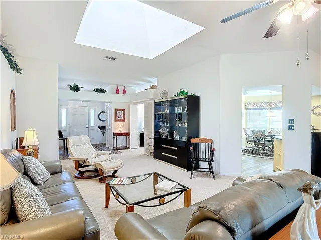Carpeted living room looking into kitchen