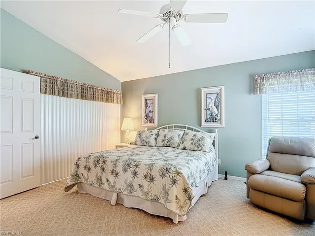 Master bedroom featuring ceiling fan and vaulted ceiling