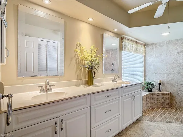 Bathroom featuring ceiling fan, dual bowl vanity, and tile patterned flooring