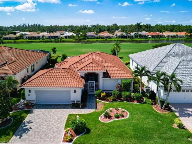 View of front of property featuring paved driveway and walkway.