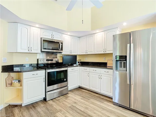 Kitchen featuring appliances with stainless steel finishes, white cabinetry