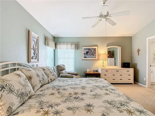 Master Bedroom featuring ceiling fan, ensuite bathroom, and carpet
