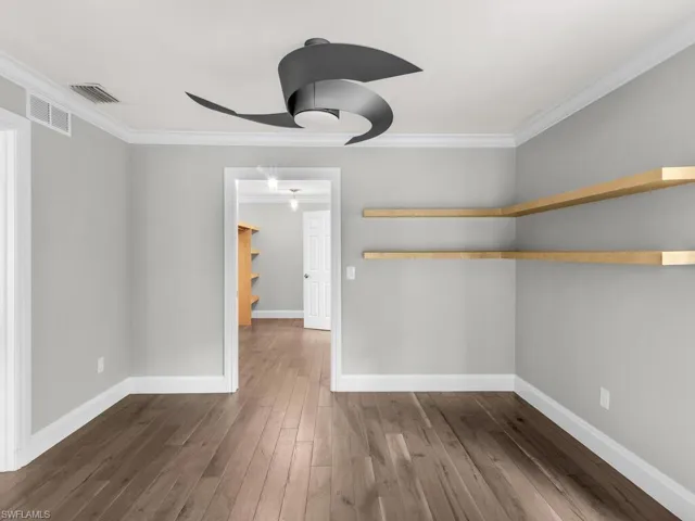 Unfurnished room with dark hardwood / wood-style flooring and ornamental molding