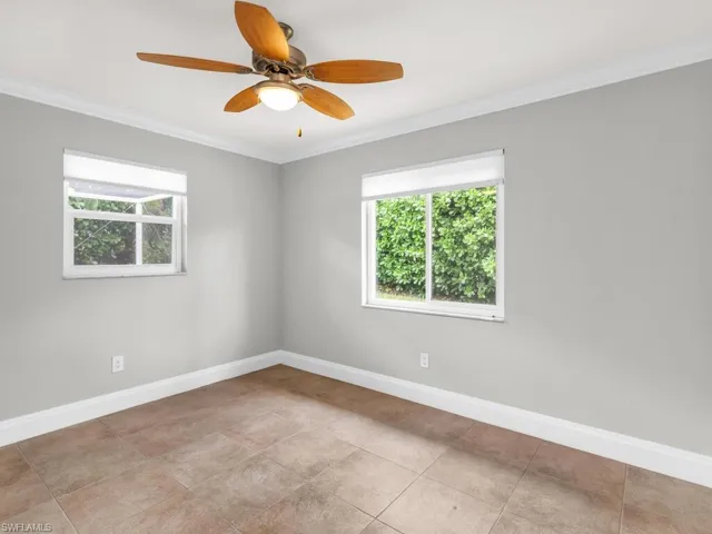 Unfurnished room with ceiling fan and crown molding