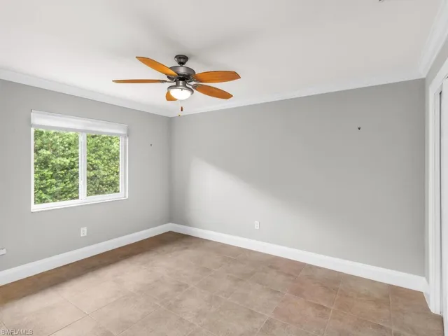 Unfurnished room with ceiling fan and ornamental molding