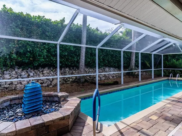View of swimming pool featuring a patio and glass enclosure