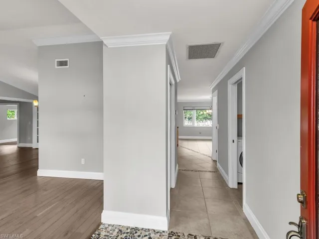 Hallway featuring light hardwood / wood-style floors, washer / clothes dryer, and ornamental molding