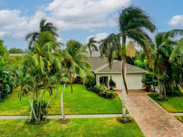 View of front of house with a garage and a front lawn