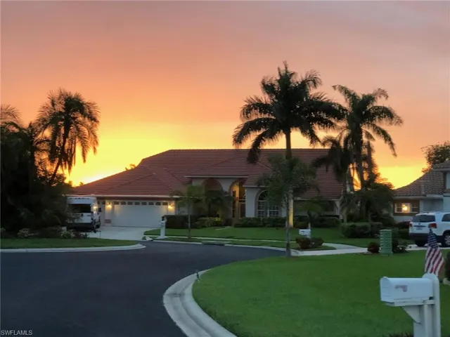 View of front of home with a garage and a yard
