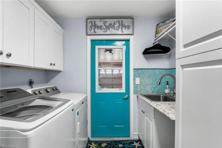 Laundry room with sink, cabinets, and independent washer and dryer