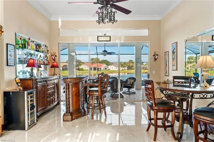 Bar featuring crown molding, plenty of natural light, and ceiling fan
