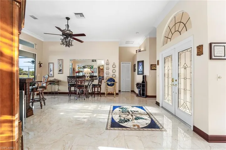 Entryway featuring ceiling fan, ornamental molding, and french doors