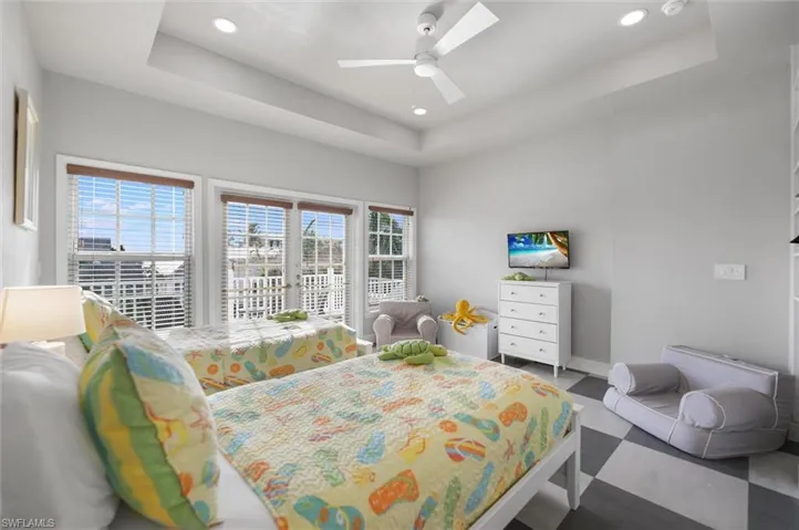 Bedroom featuring a tray ceiling, access to exterior, ceiling fan, and recessed lighting