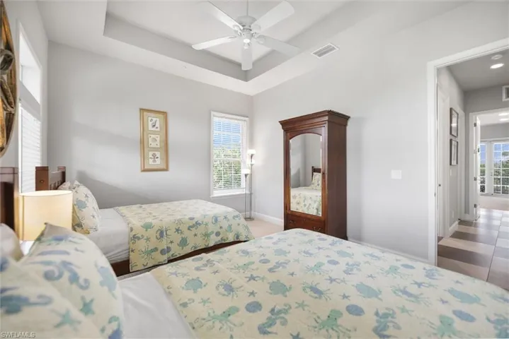 Bedroom featuring a tray ceiling and a ceiling fan