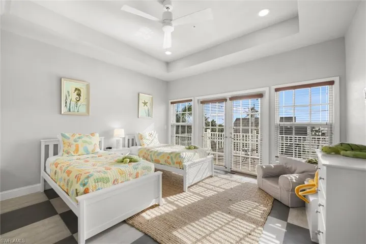 Bedroom with access to outside, a raised ceiling, a ceiling fan, and recessed lighting