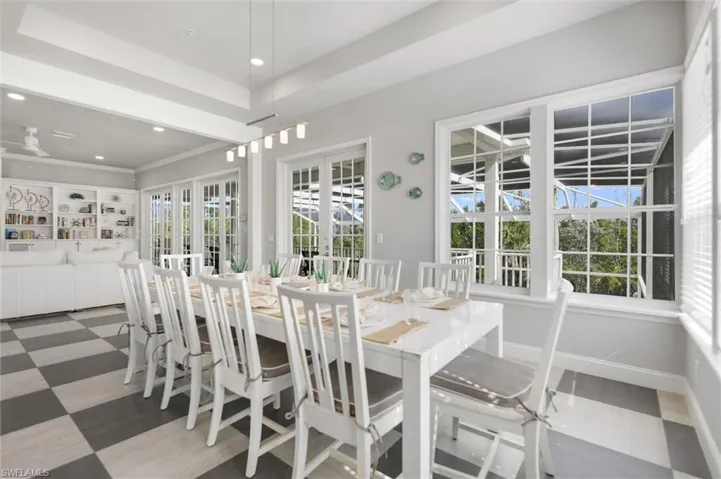 Dining area with recessed lighting, a tray ceiling, and french doors