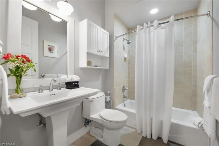 Bathroom with shower / bath combo with shower curtain and toilet