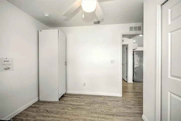 Unfurnished bedroom with baseboards, visible vents, and wood finished floors
