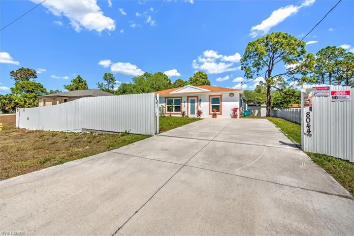 View of front of house featuring driveway and fence
