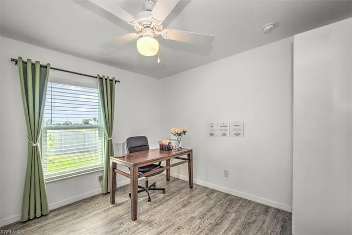 Home office featuring baseboards, wood finished floors, and a ceiling fan