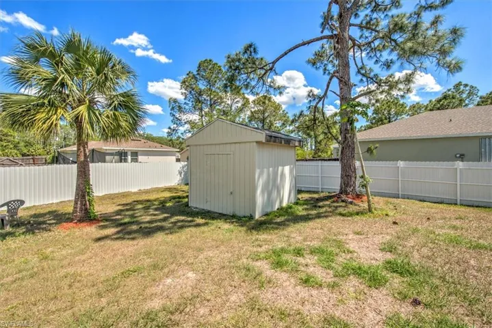 View of yard featuring a storage unit, a fenced backyard, and an outdoor structure
