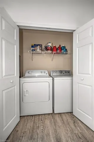 Washroom featuring washer and clothes dryer, laundry area, and wood finished floors