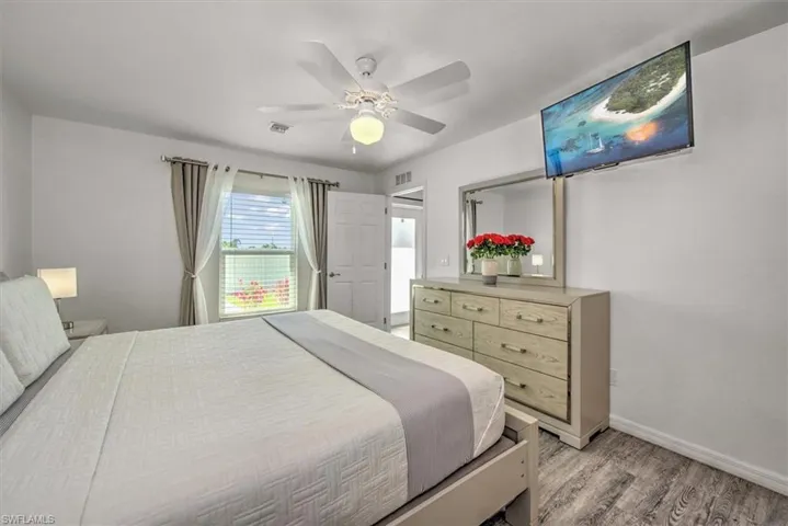 Bedroom with baseboards, visible vents, light wood-style floors, and ceiling fan