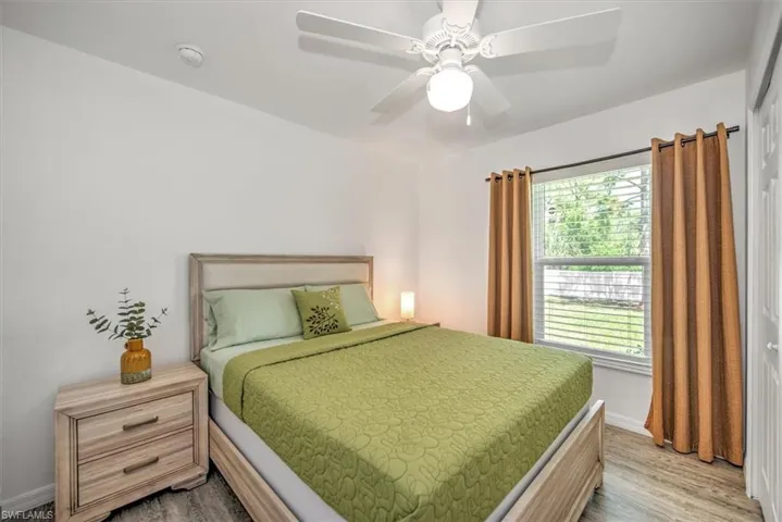 Bedroom featuring baseboards, wood finished floors, and a ceiling fan
