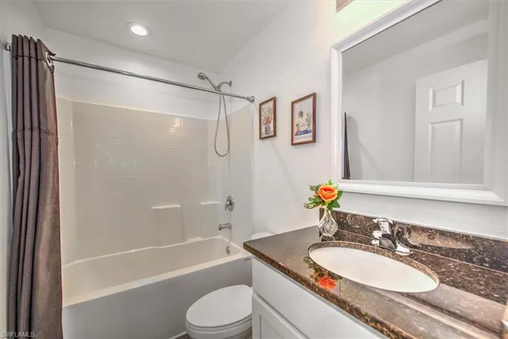 Bathroom with vanity, toilet, and shower / tub combo
