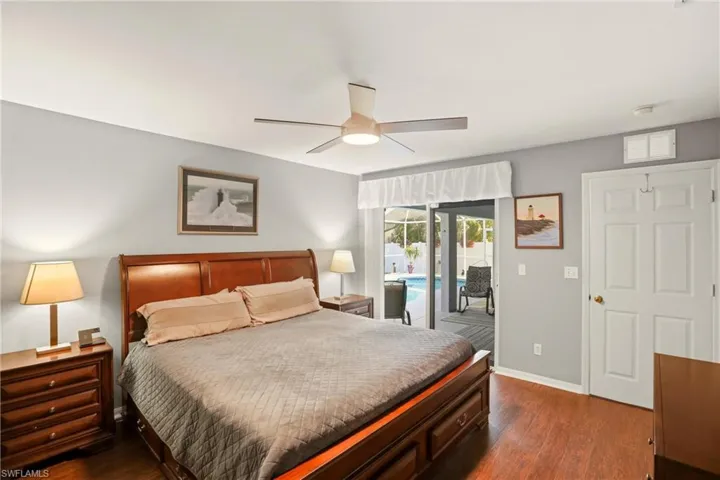 Bedroom with dark wood-style flooring, access to outside, and a ceiling fan