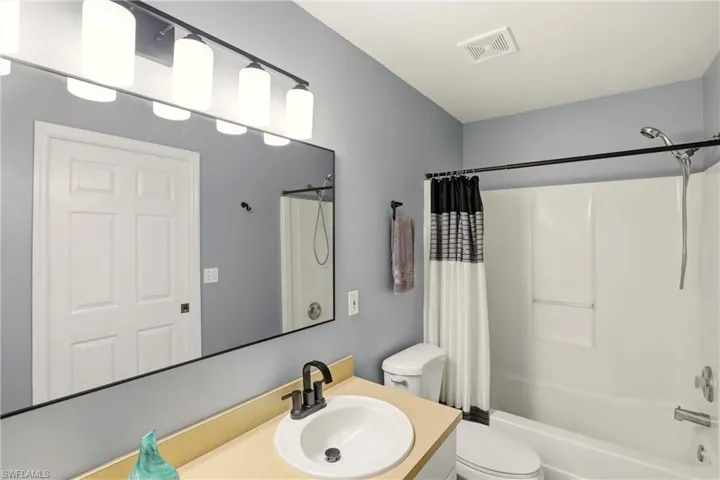 Full bathroom featuring shower / tub combo with curtain and vanity