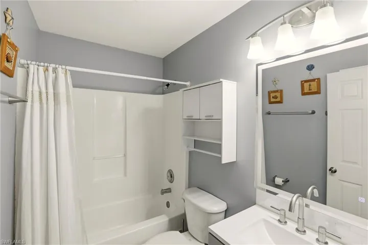 Bathroom featuring vanity and shower / bath combo with shower curtain