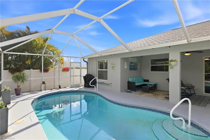 View of swimming pool with a sunroom, glass enclosure, a patio area, and an outdoor hangout area
