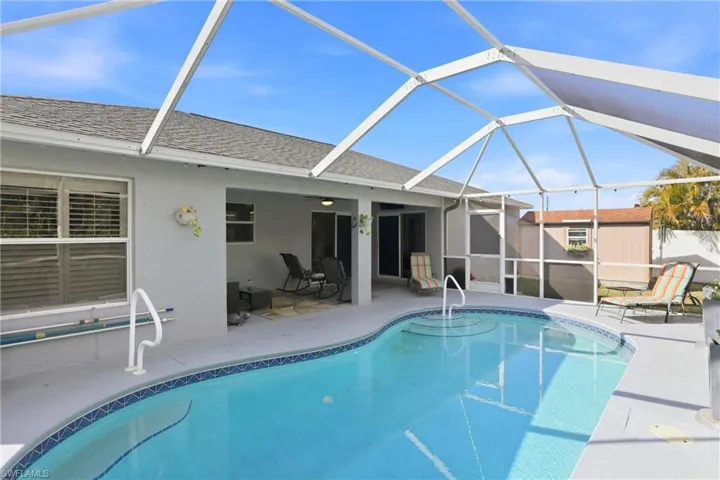 Outdoor pool featuring a sunroom, a storage unit, a patio, and a lanai