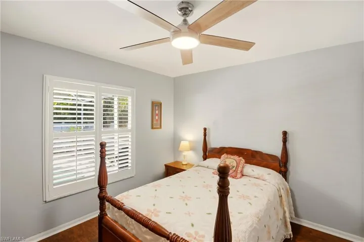 Bedroom with a ceiling fan and dark wood-type flooring