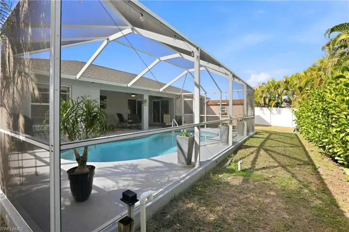 Outdoor pool with a lanai, a sunroom, a patio area, and a fenced backyard