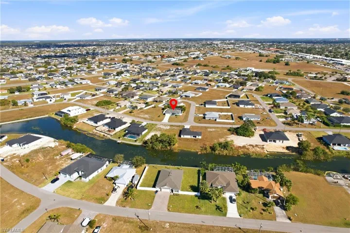 Aerial view of property's location with nearby suburban area and a nearby body of water