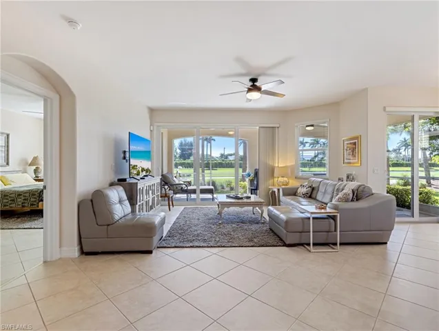 Living room featuring ceiling fan and light tile floors