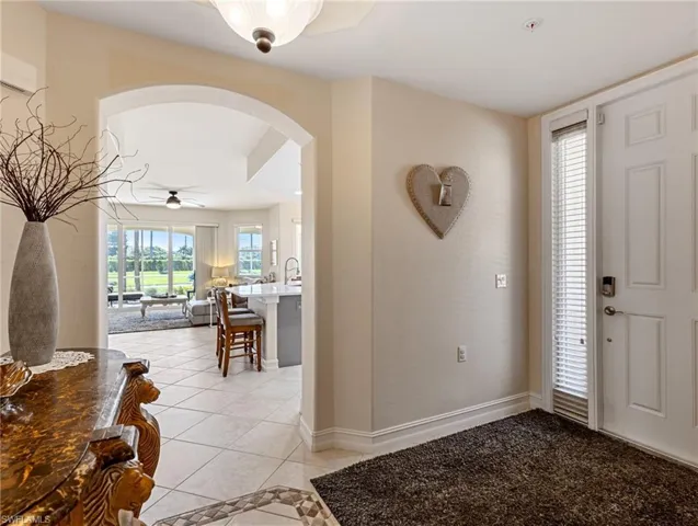 Foyer entrance featuring arched walkways, light tile on the diagonal  flooring,
