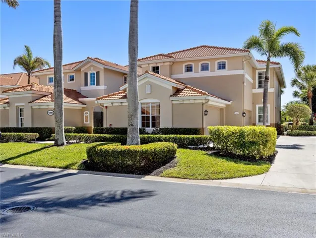 Mediterranean style home with a garage, a tile roof, driveway, stucco siding, and a front lawn