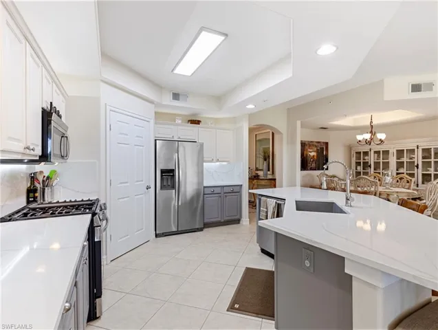 Kitchen featuring arched walkways, stainless steel appliance,s walk in Pantry