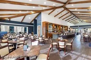 Dining area featuring wood finished floors, high vaulted ceiling, and beamed ceiling