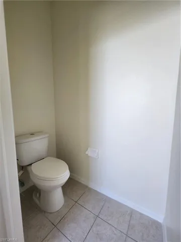 Bathroom with baseboards and light tile patterned floors
