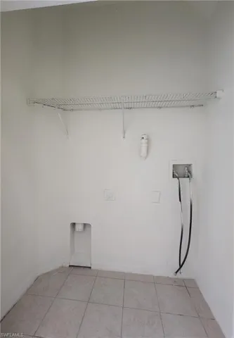 Laundry room with hookup for a washing machine and light tile patterned floors